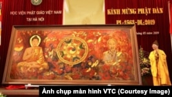 Thượng tọa Thích Thanh Quyết, cũng là đại biểu Quốc hội Việt Nam, giới thiệu bức tranh "Đạo pháp và dân tộc" tại một buổi lễ mừng ngày sinh của Đức Phật tại Học viện Phật giáo ở Sóc Sơn, Hà Nội, hôm 10/5. (Ảnh chụp màn hình VTC)