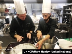 Chef of the Hotel d’Angleterre, Michael Coquelle, left, and Chef Nadeem Khadem Al Jamie, who is also a Syrian refugee, work together in the hotel's kitchen for the Refugee Food Festival, Oct. 11, 2017.
