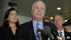 Sen. John McCain, R-Ariz., ranking Republican on the Senate Armed Services Committee, center, flanked by fellow committee members, Sen. Kelly Ayotte, R-N.H., left, and Sen. Lindsey Graham, R-S.C., right, speaks on Capitol Hill in Washington, Nov. 27, 2012