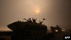 Tentara Irak mengacungkan dua jari tanda kemenangan saat berkendara melewati daerah al-Shura, arah selatan Mosul (24/10). (AFP/Ahmad al-Rubaye)