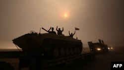 Iraqi forces flash the V-sign as they drive through the Al-Shura area, south of Mosul, Oct. 24, 2016, during an operation to retake the main hub city from the Islamic State (IS) group.