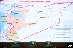 FILE - Col. Gen. Sergei Rudskoi of the Russian General Staff, from left, Deputy Defense Minister Alexander Fomin and Lt. Gen. Stanislav Gadzhimagomedov attend a briefing in Moscow, May 5, 2017. The sign on top of the map reads Syrian safe zones.