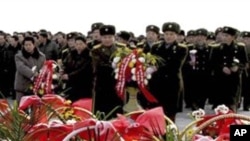 Warga Korea Utara dan tentara meletakkan karangan bunga tanda penghormatan mereka terhadap mendiang pemimpin mereka Kim Il-sung and Kim Jong-il di Mansu Hill dalam peringatan setahun wafatnya Kim Jong-il di Pyongyang, Korea Utara (16/12).