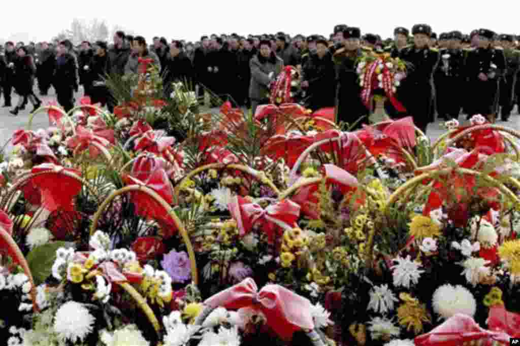 North Korean residents and soldiers offer flower baskets to show their respect for the late North Korean leaders Kim Il Sung and Kim Jong Il on Mansu Hill on the eve of the first anniversary of the death of Kim Jong Il in Pyongyang, North Korea on Sunday,