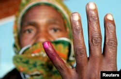 A woman shows her ink-stained finger after casting her vote in Zimbabwe's presidential and parliamentary elections in the capital Harare March 29, 2008.