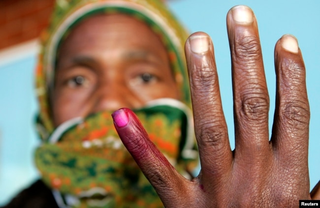 FILE - A woman shows her ink-stained finger after voting in Zimbabwe's presidential and parliamentary elections in Harare, March 29, 2008.