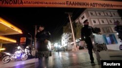 Police officers stand guard near the local offices of the neo-Nazi Golden Dawn party, following a shooting, in a northern suburb of Athens, Nov. 1, 2013.