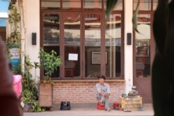 A cobbler looks for a customer while sitting patiently on an empty street in Siem Reap, Cambodia, May 11, 2020. (Phorn Bopha/VOA Khmer)