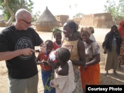 Dave Stahl helps children pump their soccer balls in Niger. (Courtesy Project Play Africa)