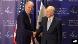 Former Israeli President Shimon Peres, right, and U.S. Vice President Joe Biden shake hands during their meeting at the Peres Center for Peace in Jaffa, March 8, 2016. 