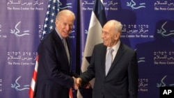 Former Israeli President Shimon Peres, right, and U.S. Vice President Joe Biden shake hands during their meeting at the Peres Center for Peace in Jaffa, March 8, 2016. 