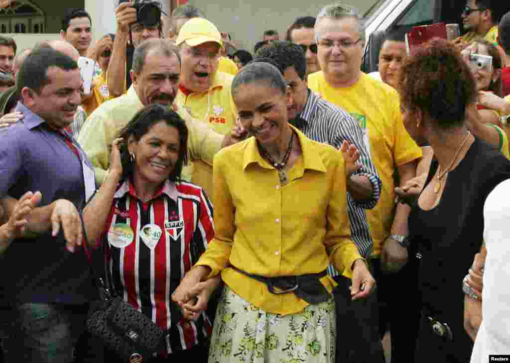 Kandidat presiden Marina Silva dari Partai Sosialis Brazil (PSB) dikelilingi para pendukungnya saat tiba untuk memberikan suara di Rio Branco (5/10). (Reuters/Odair Leal) 