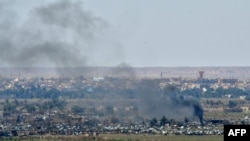 Smoke rises from the Islamic State (IS) group's last remaining position in the village of Baghuz during battles with the Syrian Democratic Forces (SDF), in the countryside of the eastern Syrian province of Deir el-Zour, March 20, 2019.