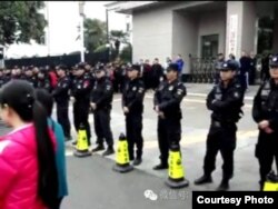 警察在中国西安市高陵区政府机关门前列队守卫。高陵民众的口号是：捍卫高陵！保卫蓝天！还我净土！抵制焚烧！在警察抓人后，他们开始高呼“放人，放人！” （2016年10月中旬，网络图片）