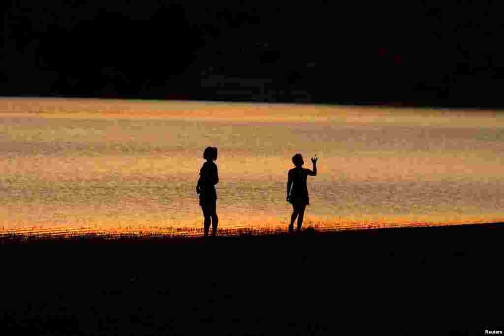 Women cool off at sunset during the first heat wave of the summer at Conde del Guadalhorce reservoir in Ardales, near Malaga, southern Spain, June 27, 2015. Temperatures will rise up to 42&deg; C (107.6&deg; F) into the weekend until June 30.