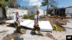 FILE - Members of the Monroe County Fire Rescue check on residents at the Driftwood Trailer Park, Sept. 12, 2017, in Tavernier, Fla., in the Florida Keys. 