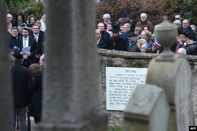 People take part in a remembrance ceremony during a rally in the Jewish cemetery of Quatzenheim, eastern France, on March 3, 2019.