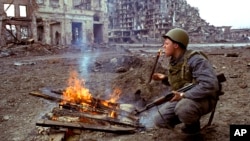 FILE - A Russian soldier lights a cigarette in the Chechen capital of Grozny, March 19, 1995. 