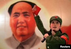 在北京一家名为“红色经典”的餐厅中，女子装扮成红卫兵手持毛主席语录在毛主席像前表演。在不少人心目中，这是少女不知乱国恨，犹唱前朝红祸歌（资料照片）