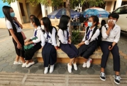 Students wearing face-masks, wait for their morning school class at Santhormok high school, in Phnom Penh, Cambodia, Monday, Nov. 2, 2020. (AP Photo/Heng Sinith)