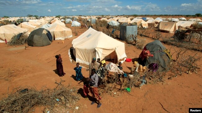 FILE - Refugees stand outside their tent at the Dadaab camp near the Kenya-Somalia border, Oct. 19, 2011. The Dadaab camp has hosted hundreds of thousands of Somali refugees for decades.