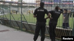 Police watch as members of the Zimbabwe cricket team practice in Gaddafi Stadium in Lahore, Pakistan, May 21, 2015. Pakistan will host Zimbabwe on May 22 after 6 years without hosting international cricket. 