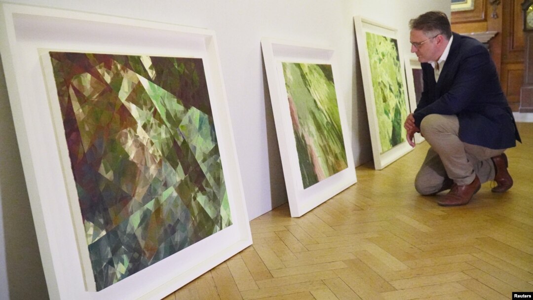 British gallery owner Aidan Meller looks at paintings created using computer vision data recorded by robot artist 'Ai-Da', the paintings form part of Ai-Da’s debut "Unsecured Futures" exhibition in Oxford, Britain, June 4, 2019.