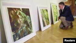 British gallery owner Aidan Meller looks at paintings created using computer vision data recorded by robot artist 'Ai-Da', the paintings form part of Ai-Da’s debut "Unsecured Futures" exhibition in Oxford, Britain, June 4, 2019.