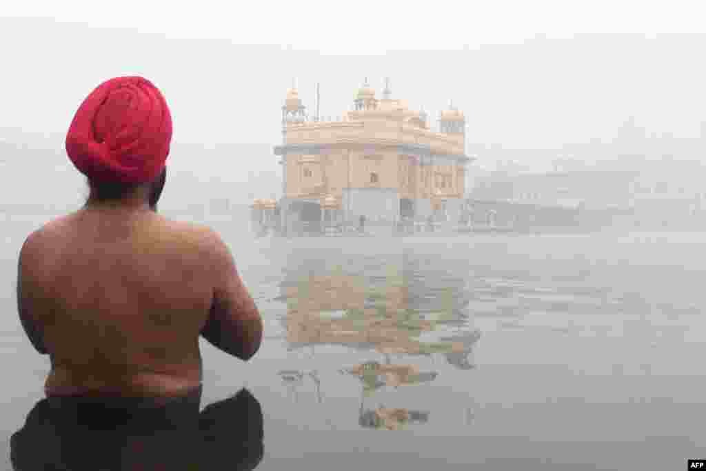 A devotee prays at the Sikh shrine the Golden Temple amid dense fog conditions in Amritsar, India.