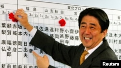 资料照- 本照片摄于2003年11月9日。当时作为执政的日本自民党总干事的安培晋三正帮着记录本党参选人的进展情况，每当本党参选人获胜，安倍就在他们的名字上面插一朵小花。67岁的日本前首相安倍晋三星期五（7月8日）在奈良遭枪击，因伤势过重，不治身亡。（路透社）