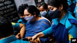 Bangladeshi journalist Rozina Islam, center, is escorted by police to a court in Dhaka, Bangladesh, Tuesday, May 18, 2021. Police charged Islam of stealing and photographing sensitive state information. (AP Photo/Mahmud Hossain Opu)