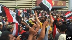 Supporters of Shiite cleric Muqtada al-Sadr raise the Iraqi flag outside parliament in Baghdad's Green Zone, April 30, 2016.