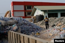 Michael Tetteh looks for glass in a trash collection area in Accra, Ghana March 18, 2022. (REUTERS/Francis Kokoroko)