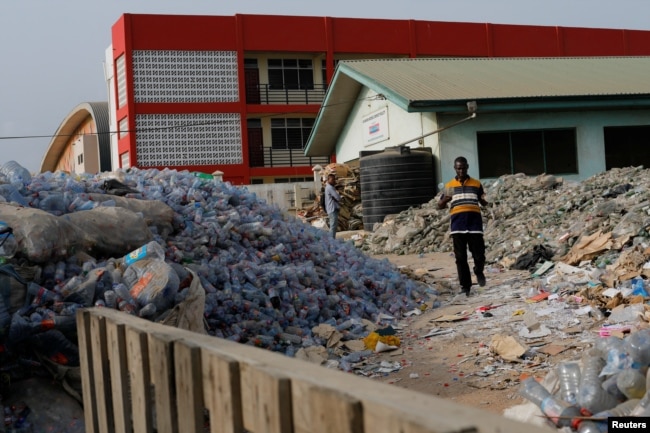 Michael Tetteh looks for glass in a trash collection area in Accra, Ghana March 18, 2022. (REUTERS/Francis Kokoroko)