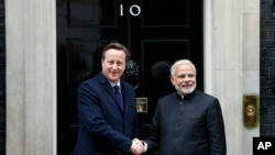 Perdana Menteri India Narendra Modi (kanan) disambut Perdana Menteri Inggris David Cameron di Downing Street No. 10 di London (12/11). (AP/Frank Augstein)