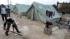 Syrian refugees shovel away water pooled outside their tents after heavy rain, at a center funded by the International Islamic Relief Organization of Saudi Arabia (IIROSA), which provides shelter for Syrian refugees in al-Marj, in the Bekaa valley, Lebanon, January 7, 2013.