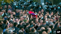 Protesters gather near the parliamentary building during a protest against an agreement to halt fighting over the Nagorno-Karabakh region, in Yerevan, Armenia, Nov. 11, 2020. 