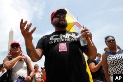 A supporter of President Donald Trump, who gave his name as Moto Moto of Brooklyn, N.Y., debates with protesters before Independence Day celebrations on the National Mall in Washington, July 4, 2019.