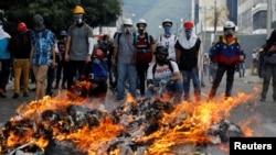 Opposition supporters stand in front of a fire during clashes with riot police at a rally against President Nicolas Maduro in Caracas, Venezuela, May 3, 2017.