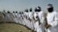 FILE - Taliban suicide bombers stand guard during a gathering of a breakaway Taliban faction, in the border area of Zabul province, Afghanistan. Eighteen bombers in training were killed in a recent airstrike in the province, Afghan officials say. 