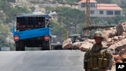 A Lebanese army soldier stands next of a rocket launcher placed on a pick up truck that was used by Hezbollah to fire rockets near Israeli positions, in the southeastern village of Shwaya, near the border with the Golan Heights, Friday, Aug. 6, 2021…