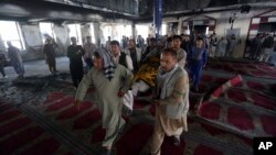 Para pria menggotong korban serangan bunuh diri di masjid Syiah, Imam Zaman, Kabul, Afghanistan, 26 Agustus 2017. 