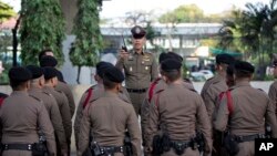 FILE - A police officer briefs others in Bangkok, Thailand, March 24, 2019. Three Thai activists remain missing after having been accused of insulting the country's monarchy.