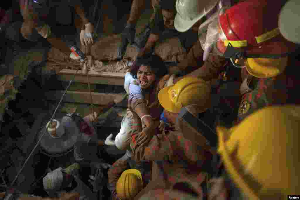 Rescue workers rescue a woman from the rubble of the collapsed Rana Plaza building in Savar, 30 km (19 miles) outside Dhaka, Bangladesh, April 27, 2013. The collapse of a garment factory complex killed more than 1,000 people.