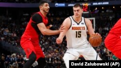 Nikola Jokić u prodoru pored Enesa Kantera u drugoj utakmici polufinala Zapada u "Ppesi centru" u Denveru (Foto: AP/David Zalubowski)