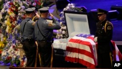 Law enforcement officer salute Dallas Police Sr. Cpl. Lorne Ahrens before his funeral service at Prestonwood Baptist Church in Plano, Texas, July 13, 2016. 