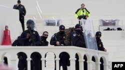 Polisi menyaksikan para pengunjuk rasa mengepung Gedung Capitol AS dan mulai menyerbunya setelah unjuk rasa mendukung Presiden AS Donald Trump di Washington, DC pada 6 Januari 2021. (Foto: AFP)