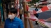 A woman wearing face mask walks on a street in Hong Kong Tuesday, Feb. 18, 2020. COVID-19 viral illness has sickened tens of thousands of people in China since December. (AP Photo/Vincent Yu)