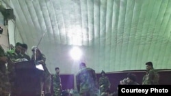 FILE - Prisoners freed from Taliban prisons in Helmand dine at an Afghan military facility. 