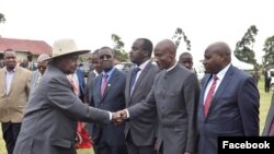 Generali Kayihura (Kulia) asalimiana na Rais Yoweri Museveni wa Uganda.